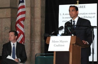 Somerville Mayor Joseph Curtatone speaks at Transportation Summit, while Transportation Secretary Richard Davey listens.