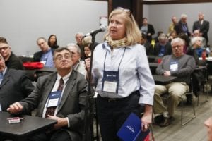 A woman speaks at microphone before room of workshop attendees at MMA Annual Meeting