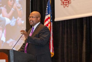 A man speaks into a microphone at a podium