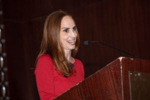 A woman stands at a podium