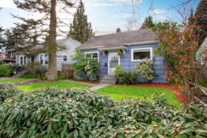 Authentic house with an abundance of greenery and an adorable walkway to white door.
