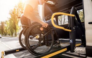 A man in a wheelchair on a lift of a specialized vehicle for people with disabilities.